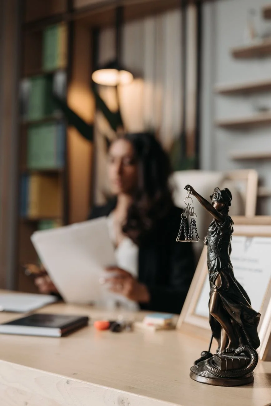 Hukuk bürosunda adalet heykeli ve çalışma alanı